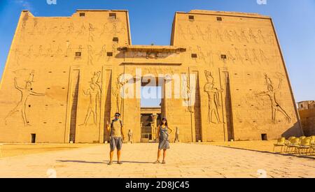 Tiro de ángulo bajo de una pareja en la entrada principal del Templo de  Horus en Edfu, Egipto Fotografía de stock - Alamy