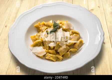 Ravioli del plin típica pasta rellena piamontesa de la Langhe En Italia sazonado con mantequilla y salvia y parmesano Foto de stock