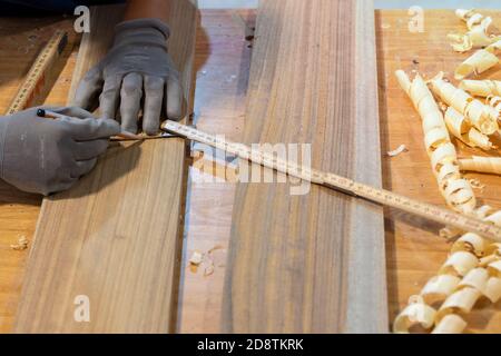Carpintero que mide madera con una regla en carpintería. Enfoque selectivo