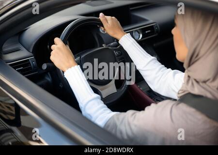 Vista trasera de una mujer musulmana que conduce su coche