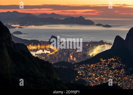 Vista de Favela Rocinha en la noche con el distrito de Ipanema detrás, en Río de Janeiro, Brasil Foto de stock