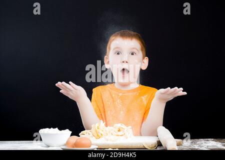 bebé jugando con harina en la cocina Foto de stock