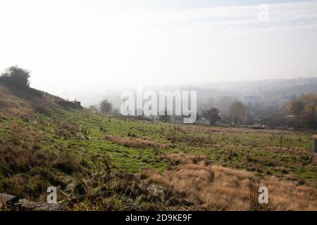 La niebla otoñal y las nubes bajas cubren el campo ondulado de las tierras altas Y granjas al pie de los Peninos cerca de Huddersfield En West Yorkshire, Reino Unido Foto de stock