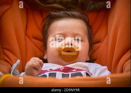 Lindo bebé con el chupete en el cochecito Foto de stock