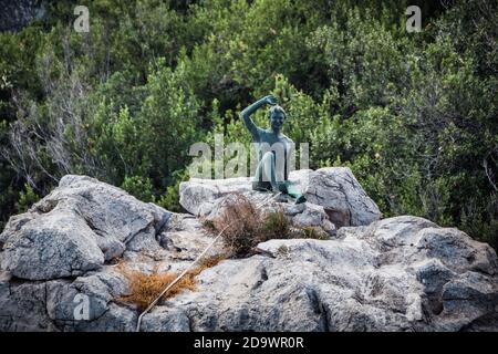 Capri, Italia - Agosto 27 2020: Gennarino Scugnizzo Estatua de un joven saludo a los visitantes en una roca Foto de stock