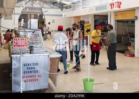 Empleados tomando las temperaturas de los clientes en un pequeño restaurante, Barrio Santiago, Mérida, México Foto de stock
