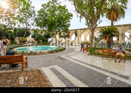 Los turistas alrededor de la fuente en los Jardines del Alto Barrakka, un jardín público en Valletta, Malta. Foto de stock