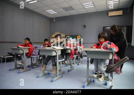(201110) -- DONGXIANG, 10 de noviembre de 2020 (Xinhua) -- alumnos asisten a clases en la Escuela Primaria Bulenggou de la aldea Bulenggou en el condado autónomo de Dongxiang de la prefectura autónoma de Linxia Hui, provincia de Gansu, al noroeste de China, el 9 de noviembre de 2020. La aldea de Bulenggou solía ser una zona muy empobrecida. Desde el comienzo del trabajo de alivio de la pobreza, la aldea ha cambiado junto con una mejor infraestructura, lo que permite a los pobladores acceder al agua potable, a las carreteras, a los centros de salud y a la escuela primaria bien equipada. La cría de ganado se ha convertido en la industria líder de la aldea de Bulenggou, donde los aldeanos ingenian Foto de stock