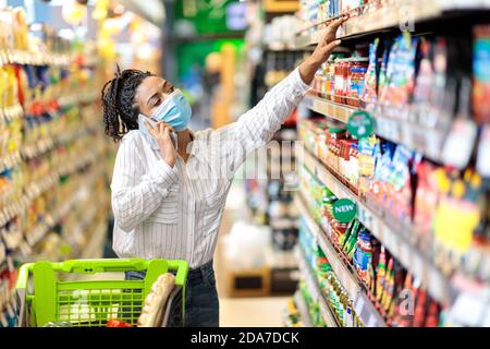 Mujer Negra hablando por teléfono comprando comida en la tienda de supermercado Foto de stock