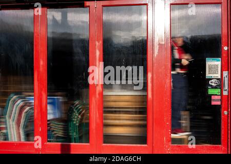 Un hombre lleva a cabo reparaciones de bricolaje detrás de vidrio esmerilado en el interior de un bar/restaurante durante el cierre 2. Londres