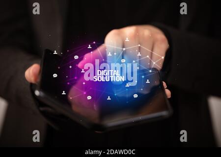 Empresario sosteniendo un smartphone plegable con solución digital inscripción, nuevo concepto tecnológico