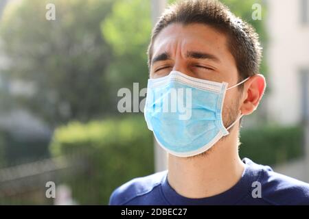 COVID-19 Coronavirus pandémico primer plano del hombre con mascarilla quirúrgica respirando al aire libre