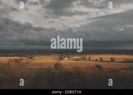 Moody tiro dramático de una pequeña granja rodeada de tierras de cultivo Otoño en el Reino Unido