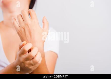 Asiática hermosa mujer picando su mano using rasguño mano picor sobre fondo blanco con el espacio de copia, médico y Healthcare concepto Foto de stock