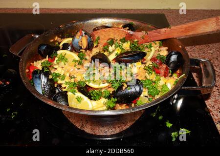 Una cacerola de paella de mariscos lista para servir la estufa Foto de stock