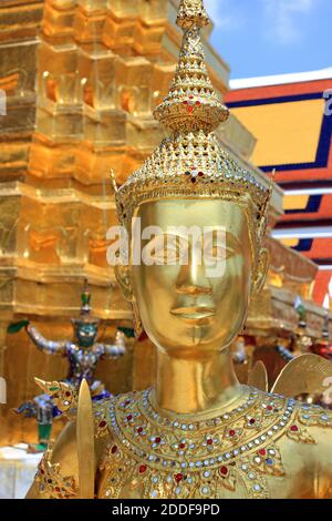 Estatua de Kinnara (criatura mitológica, medio pájaro, media mujer) junto al meji dorado en Wat Phra Kaew, Bangkok, Tailandia