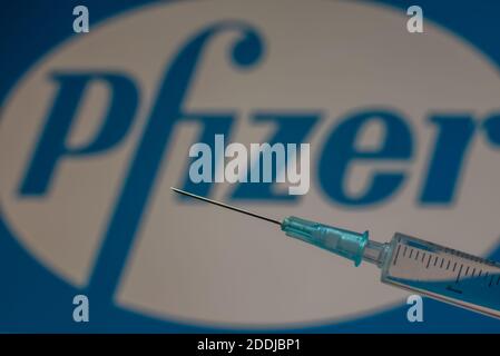 Vacuna Pfizer covid-19 en una jeringa delante del logotipo de la empresa, Dinamarca, 24 de noviembre de 2020