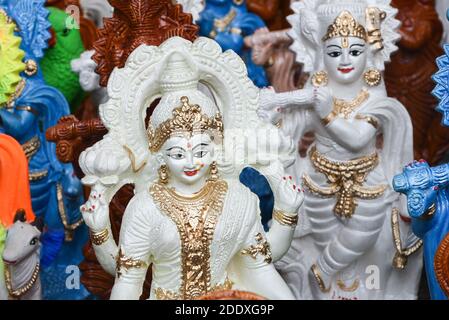Muchas esculturas coloridas de la estatua de dios hindú, el señor Krishna en una tienda de la calle, Delhi, India Foto de stock