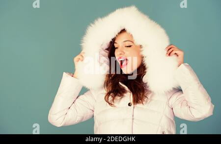 La ropa de invierno. Chica vestir chaqueta invierno fondo azul. La  temporada de invierno. Piel suave. Código de estilo y elegancia. Mujer  desgaste abajo chaqueta con capucha peluda. Para aquellos que deseen