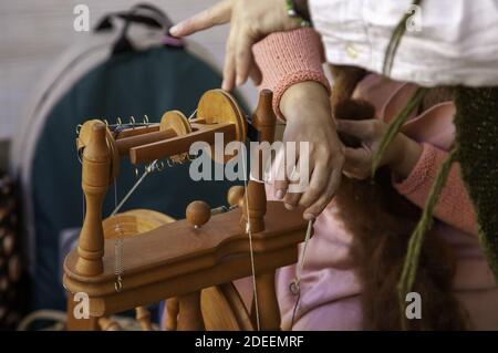 Hiladora trabajando en costura con lana, producción artesanal, industria Foto de stock