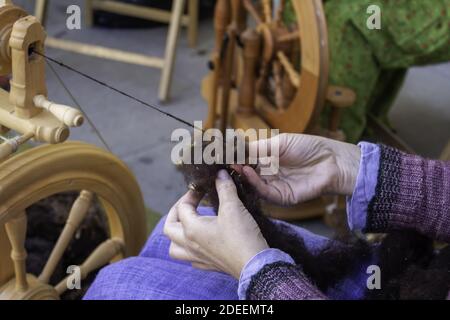 Hiladora trabajando en costura con lana, producción artesanal, industria Foto de stock