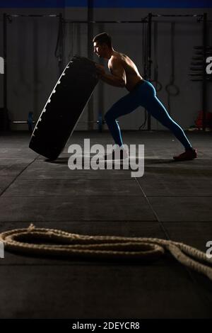 Entrenamiento Crossfit - hombre volteando neumático en gimnasio Fotografía  de stock - Alamy