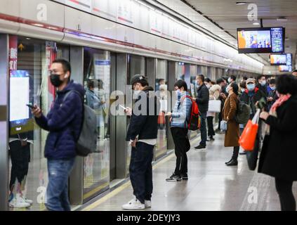 (201202) -- SHANGHAI, 2 de diciembre de 2020 (Xinhua) -- los pasajeros esperan en la estación Xujiahui de la línea 1 del metro de Shanghai en Shanghai, China oriental, 2 de diciembre de 2020. Las metrópolis chinas de Beijing y Shanghai han lanzado un servicio que permite a los pasajeros del metro utilizar el mismo código QR para pagar las tarifas de los billetes en ambas ciudades.es común en China que los pasajeros del metro utilicen un código QR para los pagos, que normalmente se escanea en las puertas de los billetes. Sin embargo, los códigos se encuentran a menudo en diferentes aplicaciones desarrolladas en diferentes ciudades y no se pueden utilizar indistintamente. El servicio, efectivo el martes, permite el código QR en la r Foto de stock