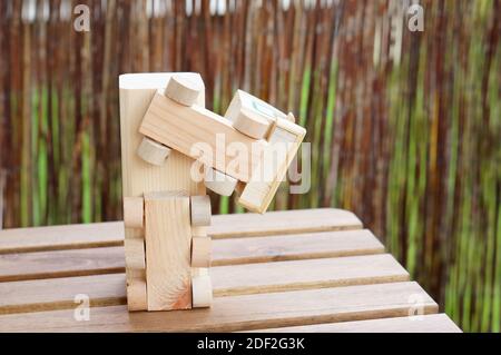 Un camión de juguete de madera hecho a mano de pie boca abajo en un mesa de madera