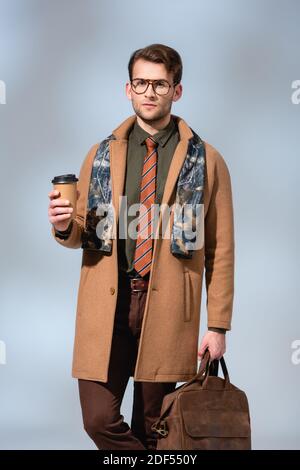 hombre con estilo en de invierno con café para llevar y maletín de cuero en gris de stock Alamy