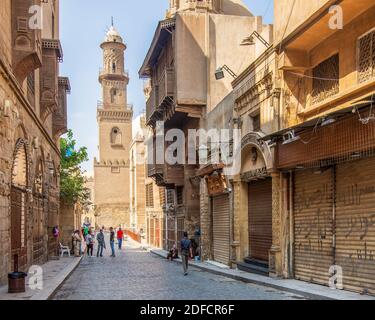 El Cairo, Egipto - Junio 26 2020: Calle Moez con trabajadores, pocos visitantes locales y minarete del complejo histórico Qalawun edificio, durante el período de cierre de Covid-19, distrito de Gamalia, el Viejo Cairo