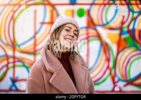 Atractiva mujer joven con largo cabello trenzado de moda mirando a través  de los listones de madera sobre un restaurante Fotografía de stock - Alamy