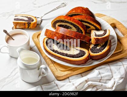 strudel de semillas de amapola en un plato blanco con bebida caliente de  cacao en una taza sobre una mesa de mármol, strudla od maka, receta croata,  vista horizontal desde arriba Fotografía