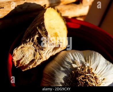 El bulbo de ajo fresco y el jengibre de la raíz que se almacena en un alféizar de ventana de la cocina Foto de stock