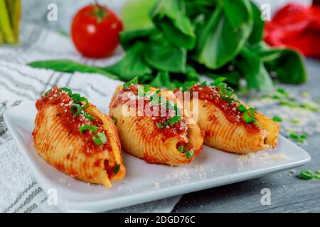 Conchas de pasta llenas de quesos de ricotta, salsa de tomate y cebollino. Foto de stock