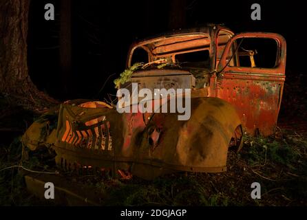 Camiones antiguos abandonados oxidación en el bosque en la noche