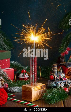 velas de bengalas brillantes de navidad se queman en el fondo del árbol de  navidad. decoración de iluminación navideña en el interior de la casa.  luces de chispas mágicas festivas para fiestas