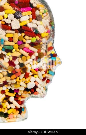 Ein Kopf aus Glas mit vielen Tabletten gefüllt. Symbolphoto für Medikamente, Mißbrauch und Tablettensucht.