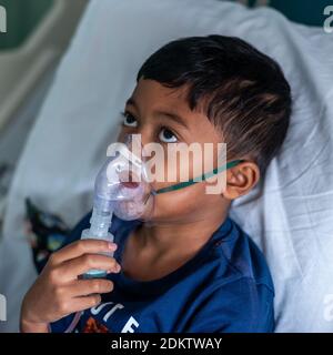 Niño usando nebulizador en el hospital