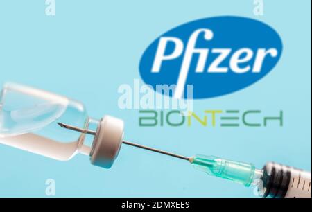 Athens, Greece. December 17, 2020. Pfizer and BioNTech logos on blue background. Covid19 vaccine vial and syringe, Coronavirus immunization concept Stock Photo