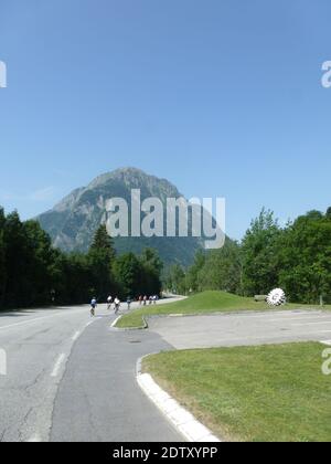 Vista al paisaje con carretera y ciclistas en Auvernia en Francia Foto de stock