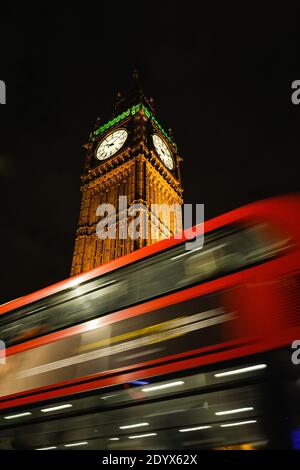 despiértese del autobús rojo que pasa por el Big Ben y el Parlamento británico por la noche. Londres, Reino Unido