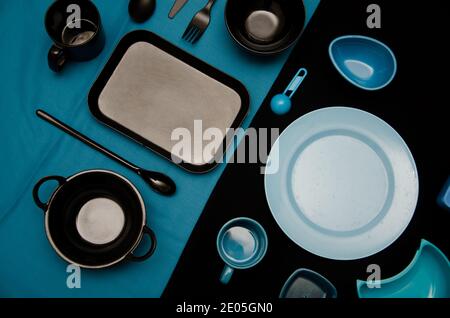Conjunto de platos de color azul sobre fondo negro y negro Platos de colores sobre fondo azul Foto de stock
