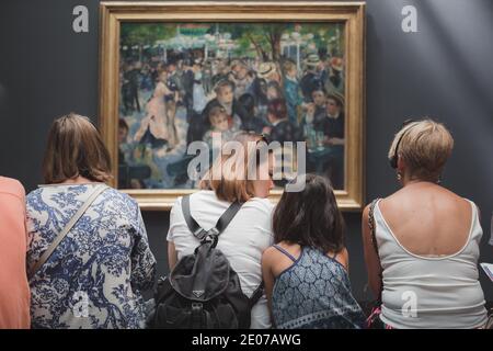 París, Francia - 22 de agosto de 2015: Visitantes del Musee d'Orsay mirando la famosa obra maestra de Renoir 'Bal du moulin de la Galette' Foto de stock