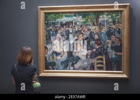París, Francia - 22 de agosto de 2015: Un visitante al Musee d'Orsay mirando la famosa obra maestra de Renoir 'Bal du moulin de la Galette' Foto de stock