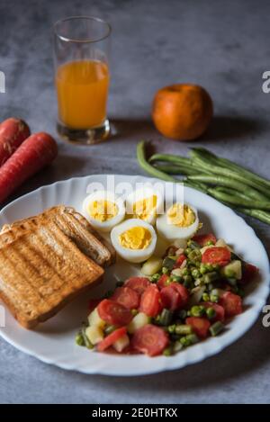 Rebanada de huevo junto con pan y verduras