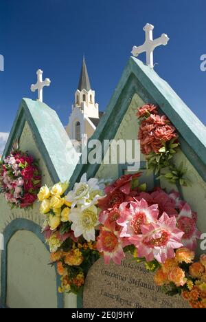 Flores adornan criptas en el cementerio junto a la histórica y colorida Iglesia Católica de Santa Ana, Noord, Aruba.