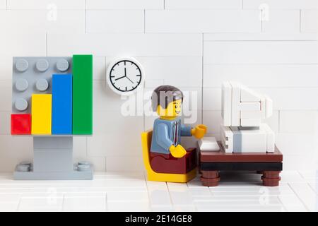 Tambov, Federación Rusa - 03 de enero de 2021 Lego empresario minifigure sentado detrás de una computadora y trabajando en ella. Foto de stock