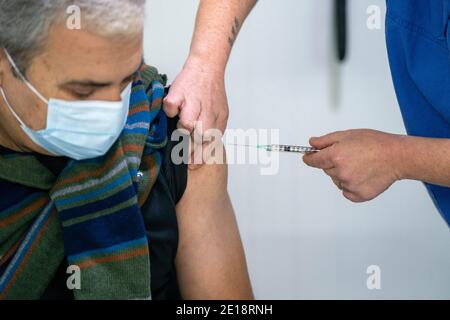 Enfermera vacunando a un hombre con la vacuna Pfizer-BioNTech Covid 19 Foto de stock