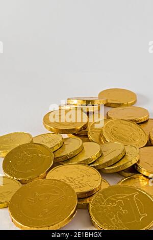 monete di cioccolato mucchio sparpagliate in verticale Foto de stock