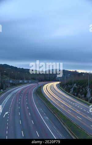 Hermosa exposición muy larga vista nocturna de los senderos de luz de los vehículos en la autopista M50 Dublín, Irlanda. Transporte durante el nivel 5 en Dublín Foto de stock